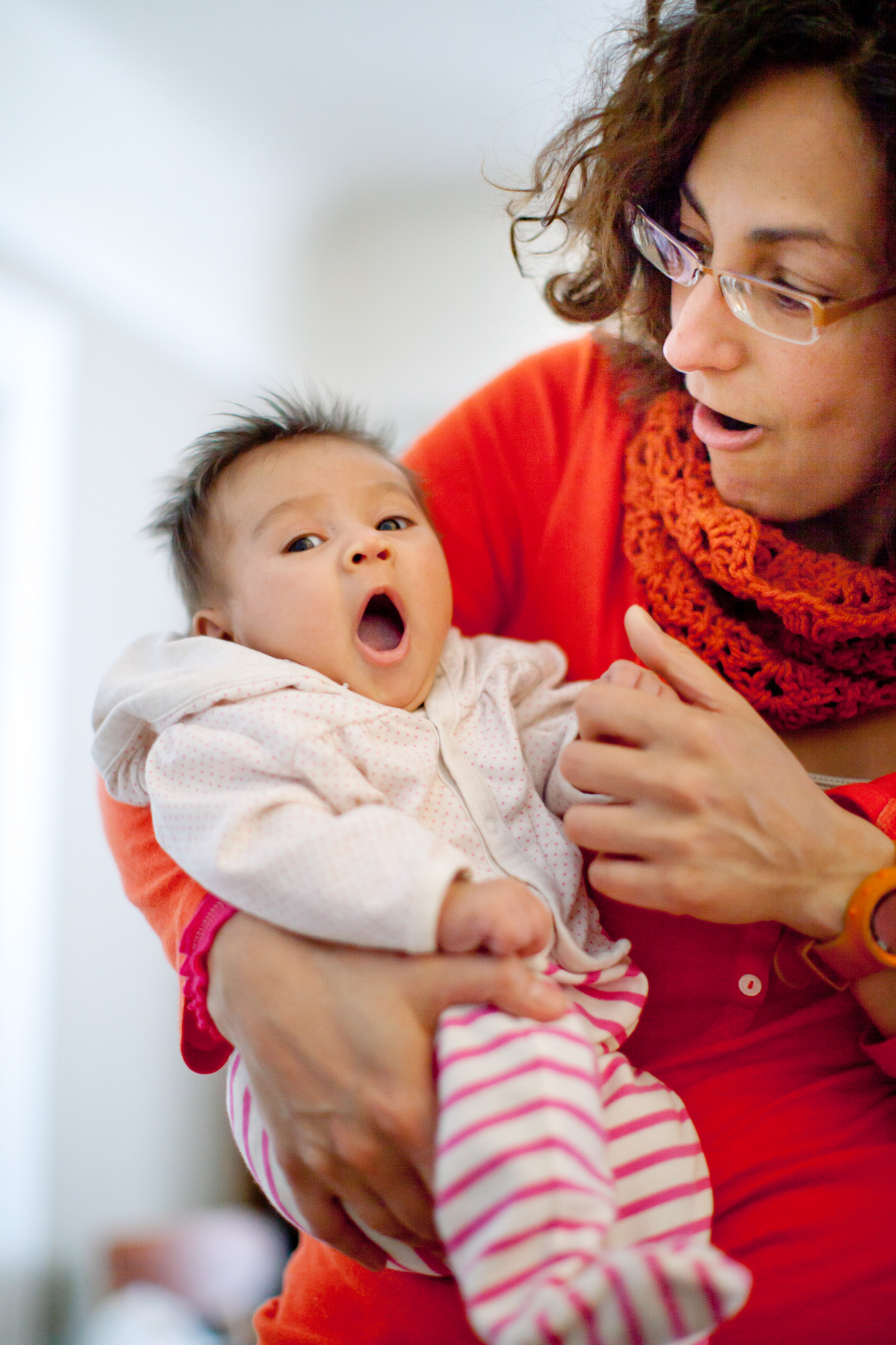 A woman holds her yawning infant daughter