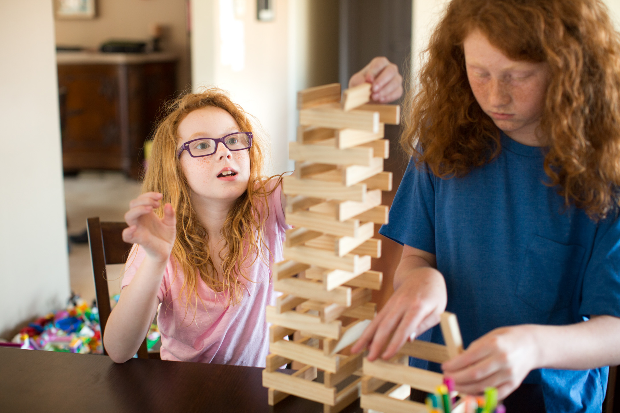 A girl + her older brother play Jenga together