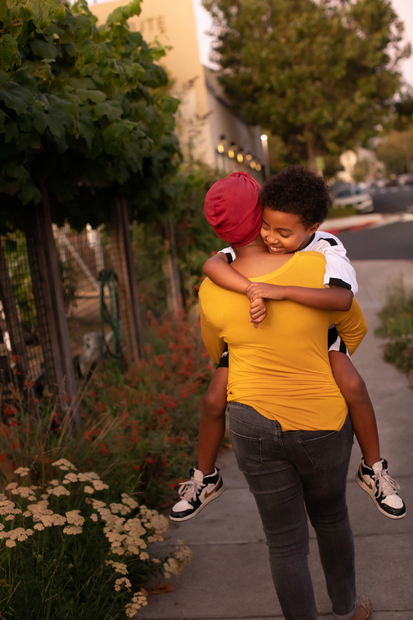 A woman and her son walk through Oakland at sunset