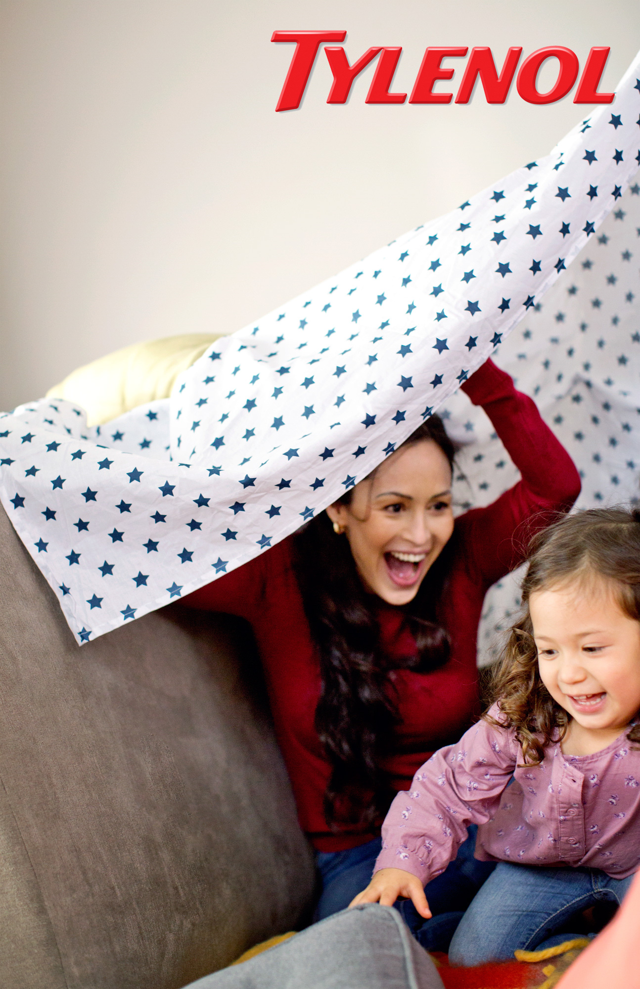 A woman plays in a blanket fort with her toddler daughter in a Tylenol Ad Campaign photographed by Lifestyle Photographer Diana Mulvihill