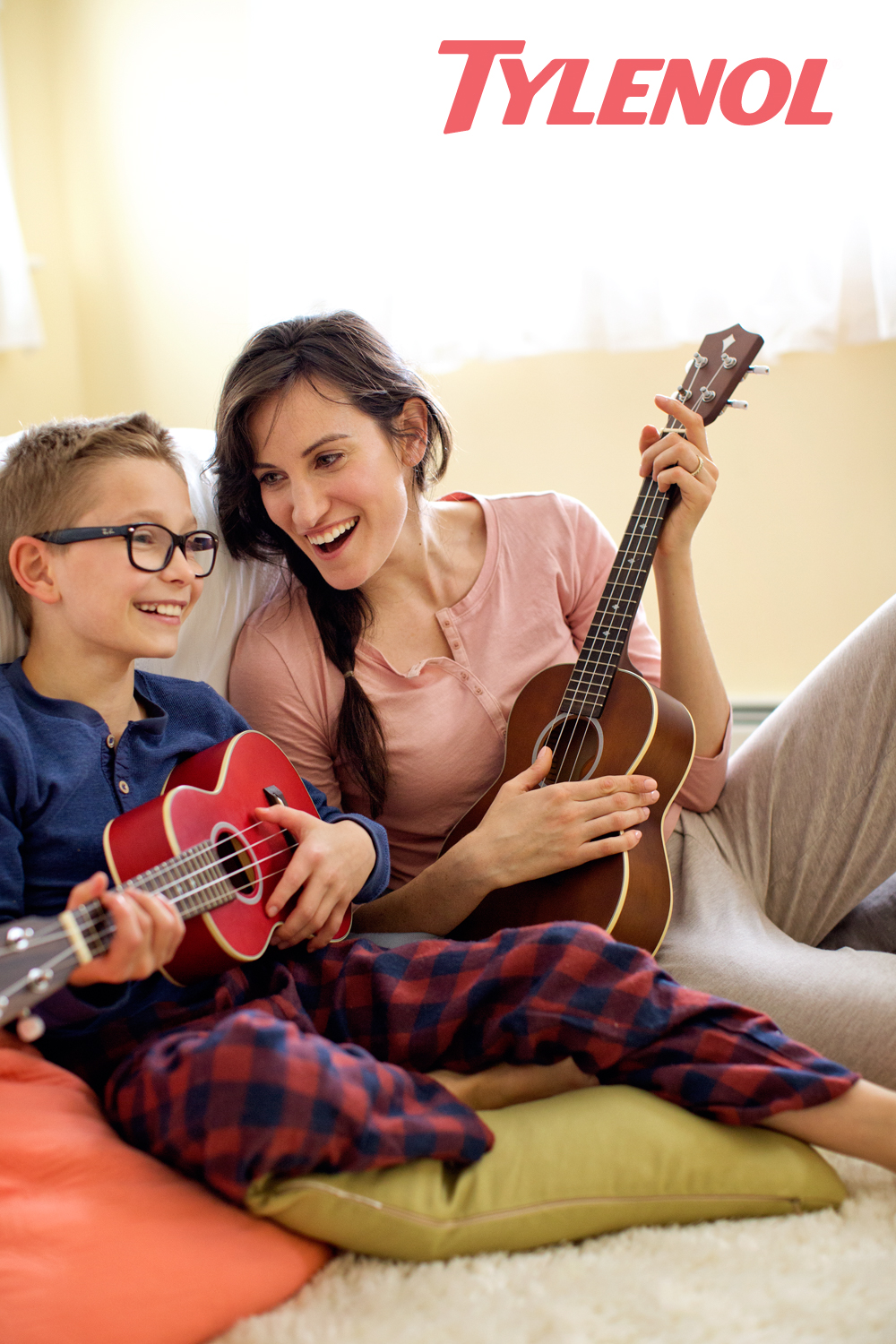 A woman plays ukulele with her son in a Tylenol Ad Campaign photographed by Lifestyle Photographer Diana Mulvihil