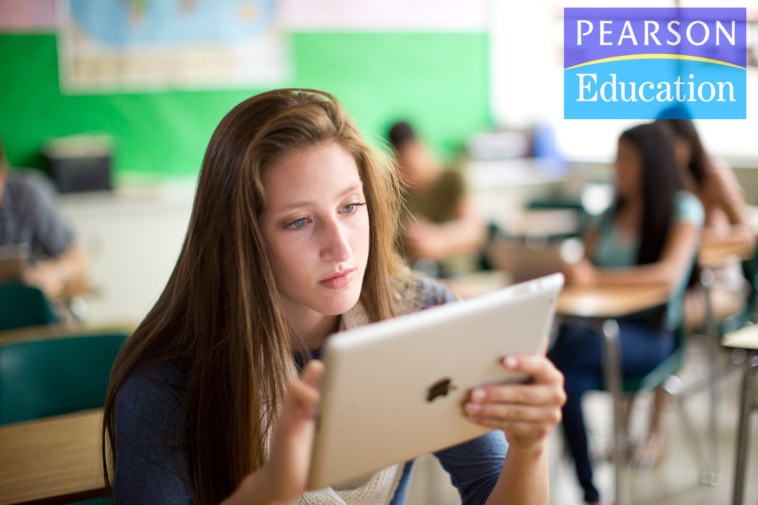 A teen girl works on an iPad in a classroom in an Ad Campaign for Pearson Education photographed by Lifestyle Photographer Diana Mulvihill